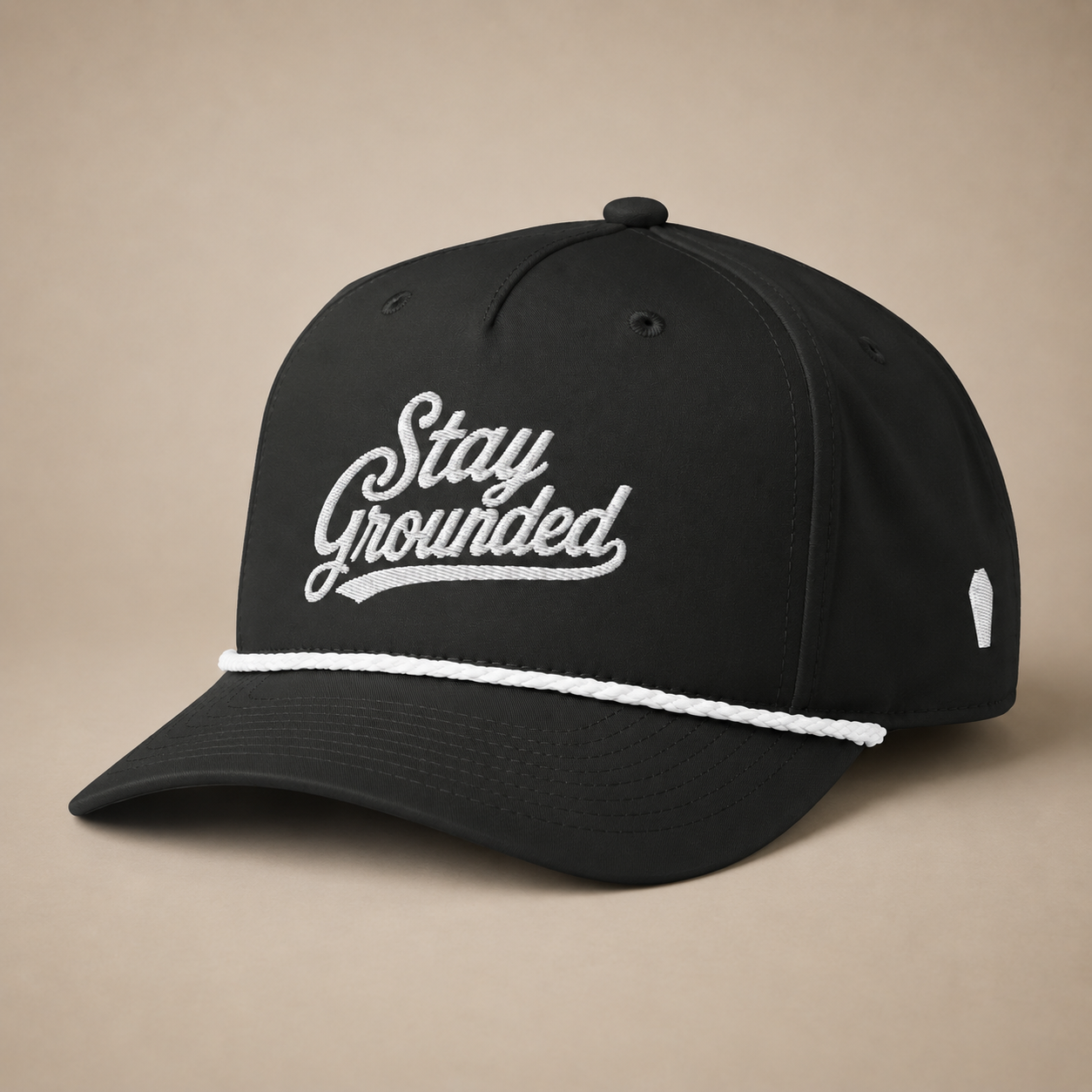 Black cap with 'Stay Grounded' text on a beige background