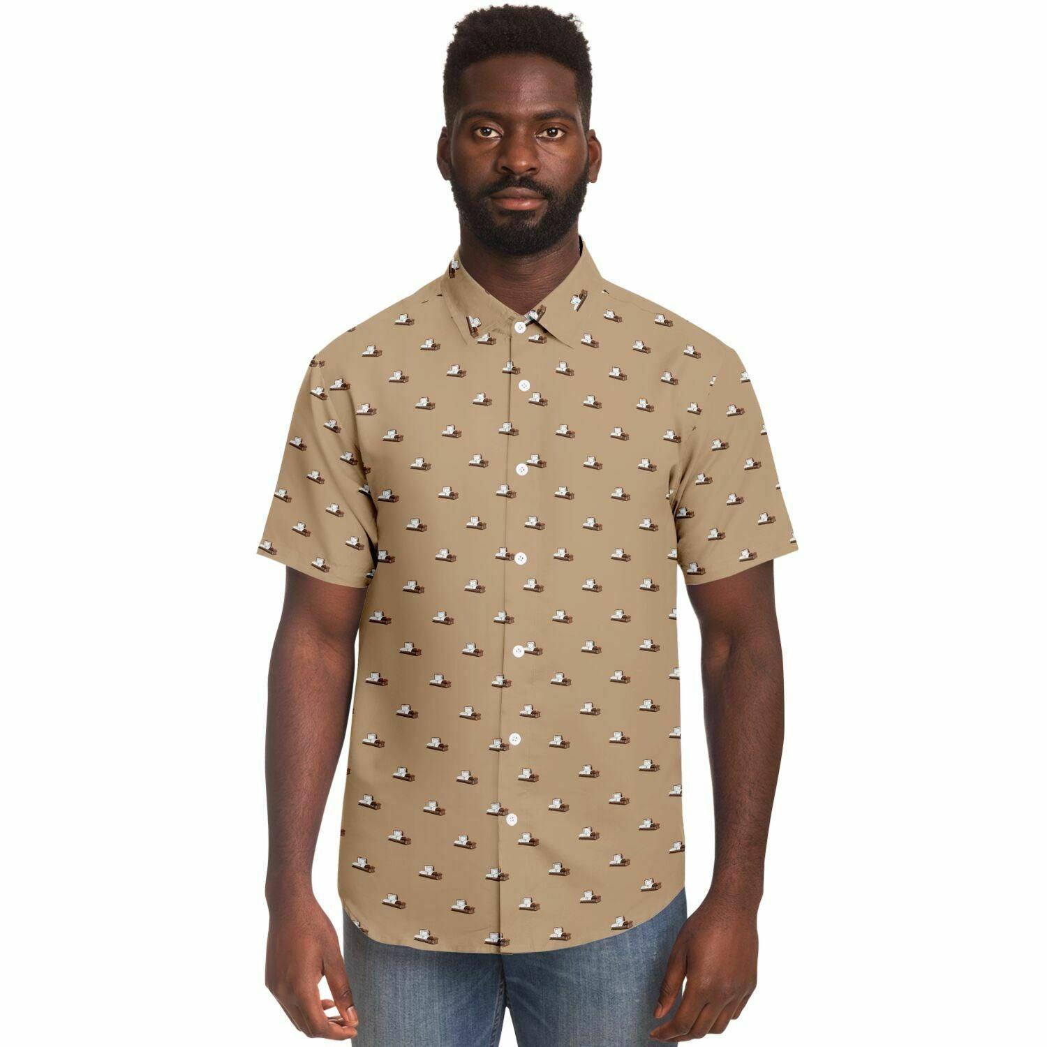 Front view of male model wearing a light brown button up tshirt with a dark brown coffin pattern on it. The casket is open.