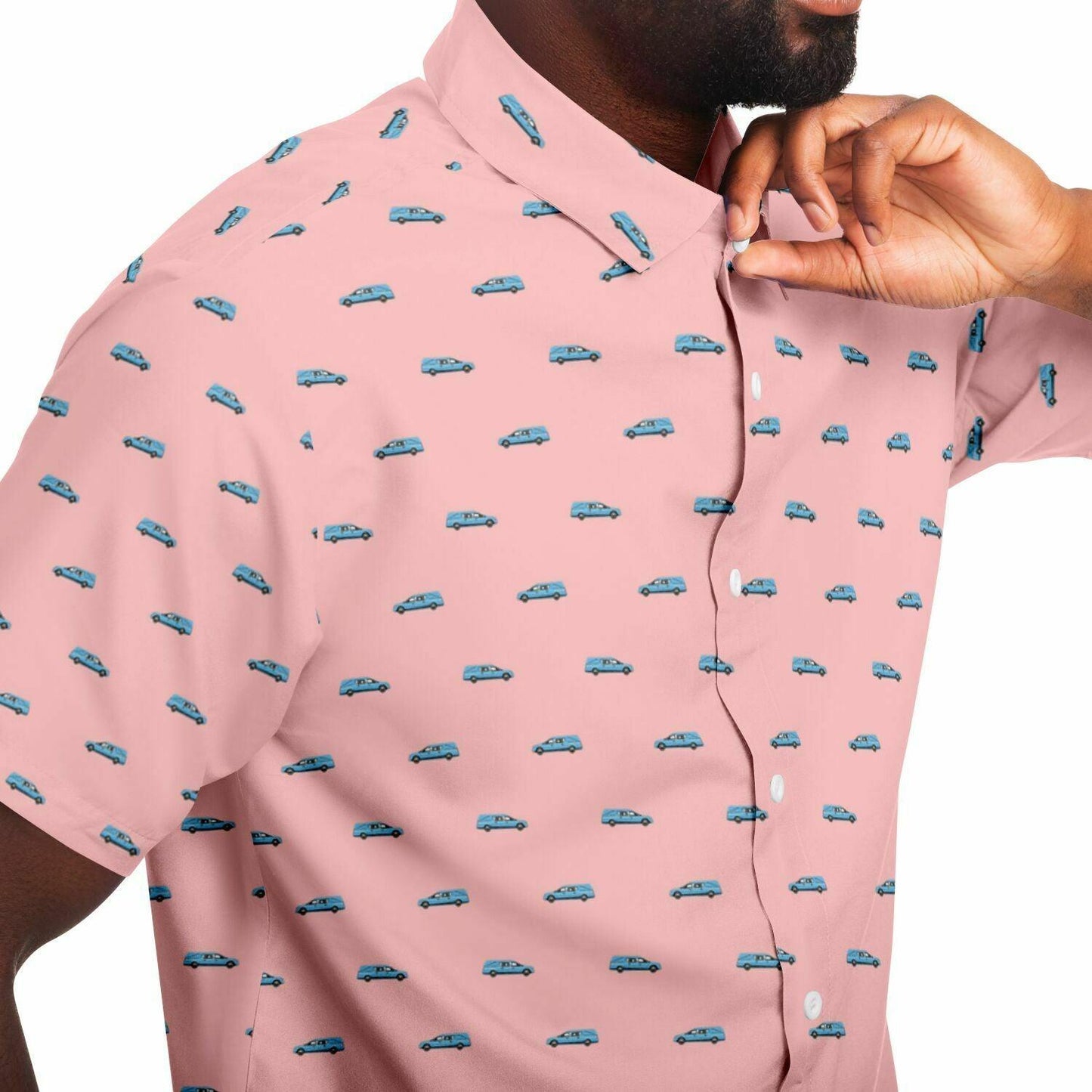 Man wearing a light pink short sleeve button down tee with a pattern containing light blue hearses. Close up side view of button up.