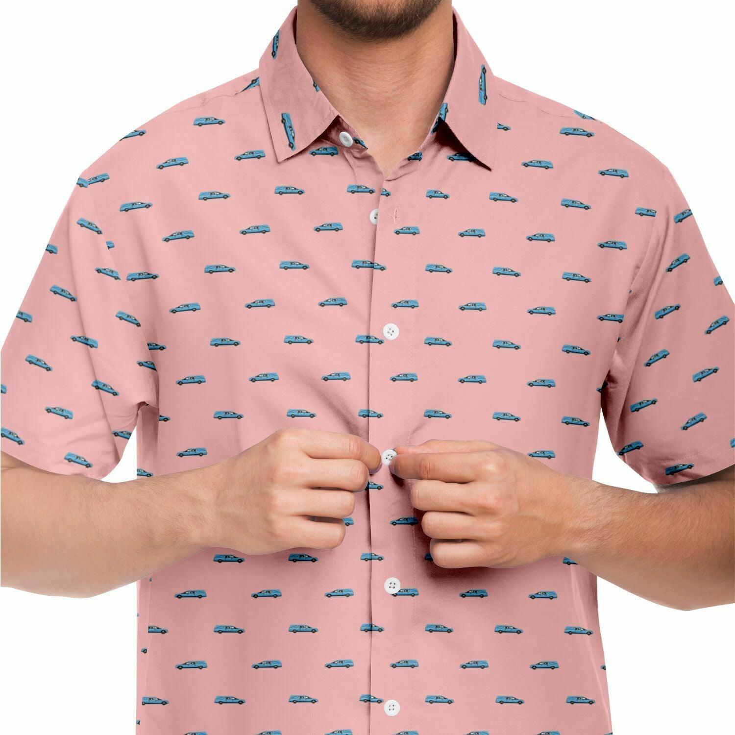 Man wearing light blue hearse patterned button up short sleeve shirt in pink. Close up front view.