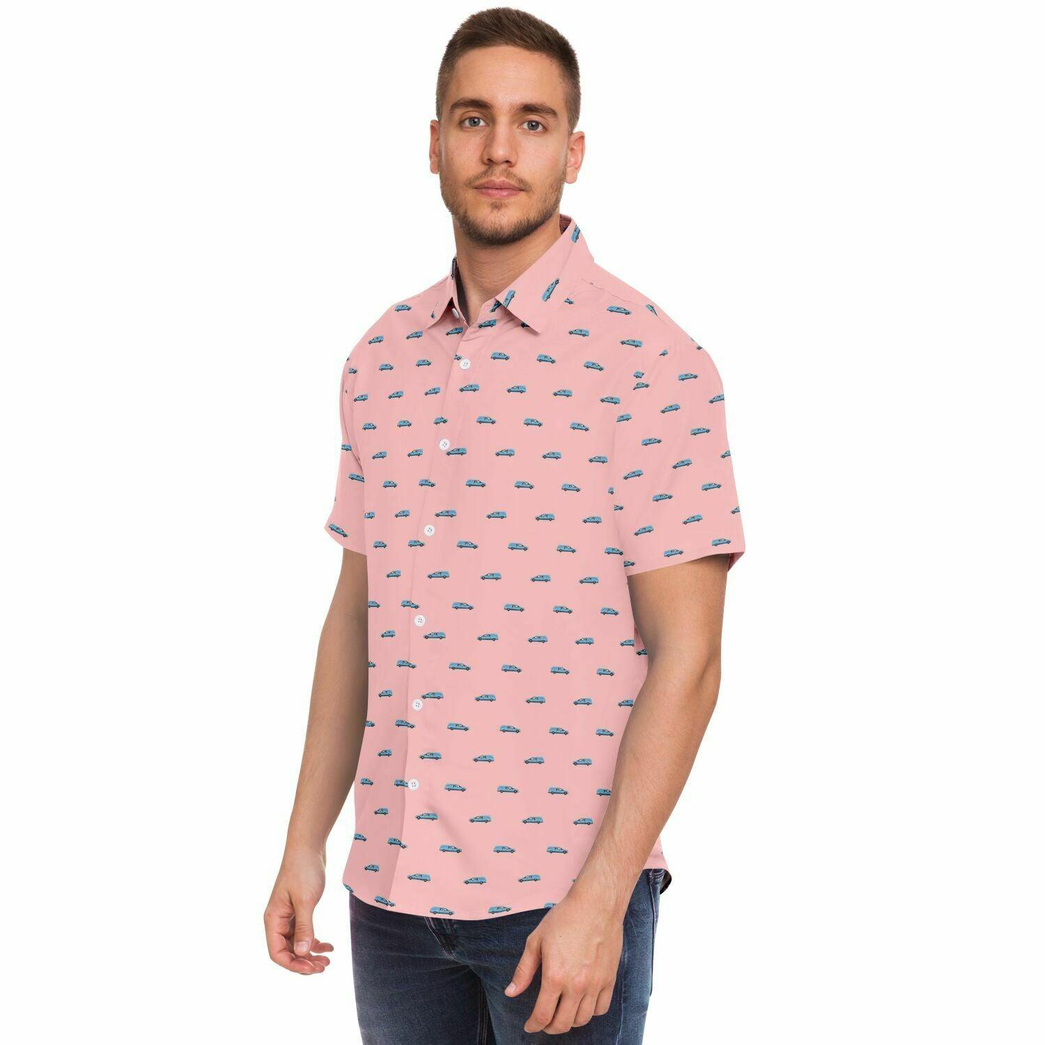 Male model wearing a light pink button down tee with pattern containing a light blue hearse on it. Frontal side angle view.