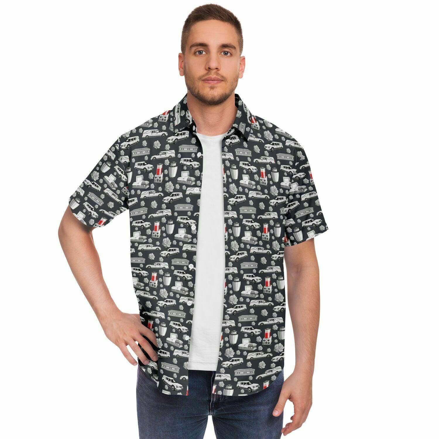 front view model with open tshirt, button up tee, it's dark grey with a pattern on it containing funeral hearses, coffins, caskets, urns, and embalming machine