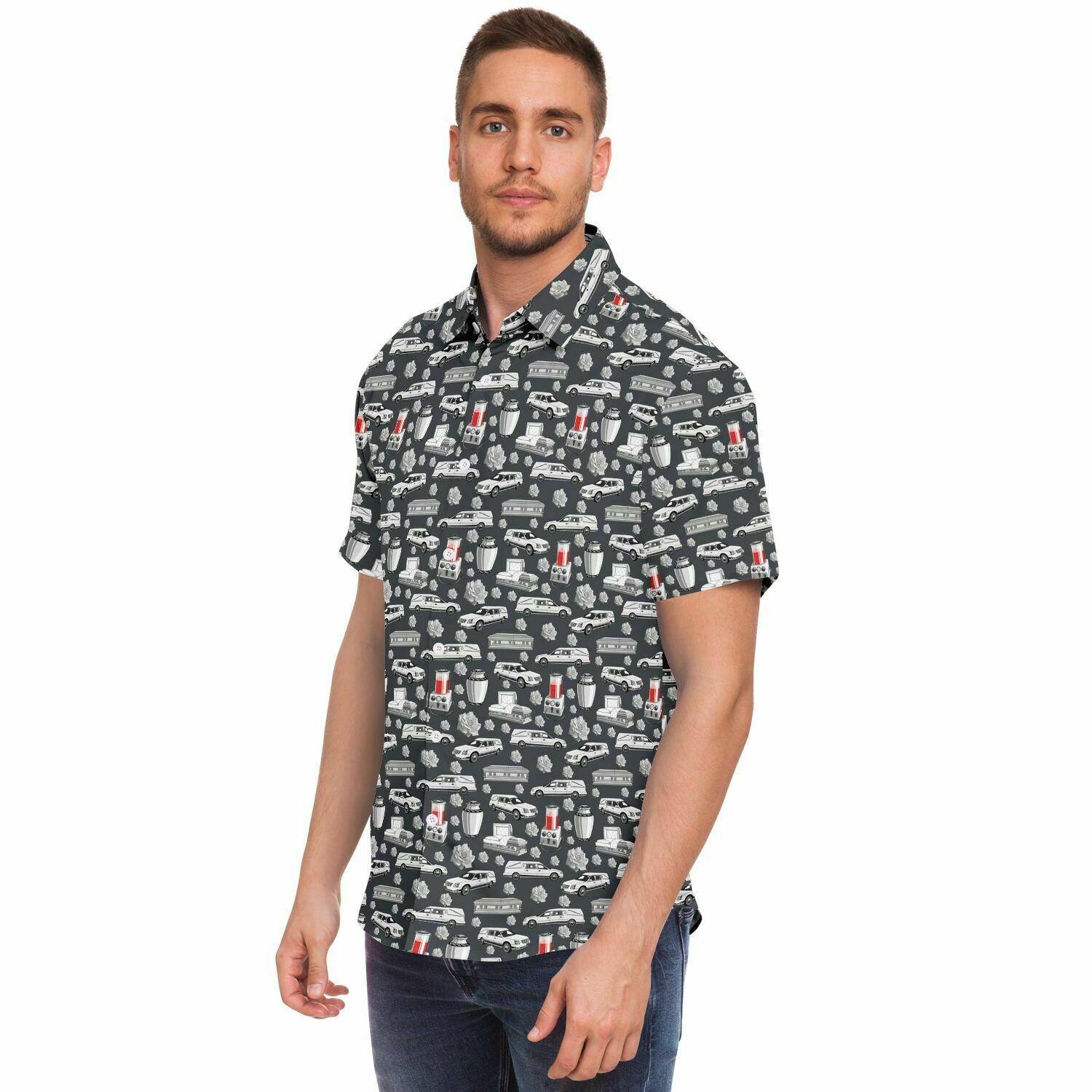 Grey button up tshirt with white pattern containing: funeral hearse, coffin, casket, cremation urn, roses, embalming machine, in white. side view